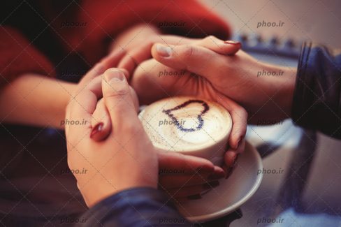 عکس با کیفیت فنجان نسکافه و دست های خان و آقا اطراف آن