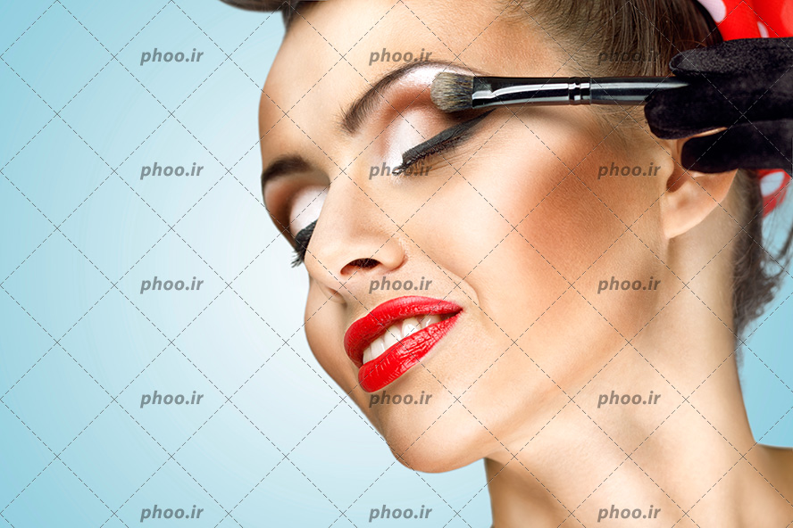 عکس خانم زیبا در حال آرایش چشم با قلم مو آرایشی
