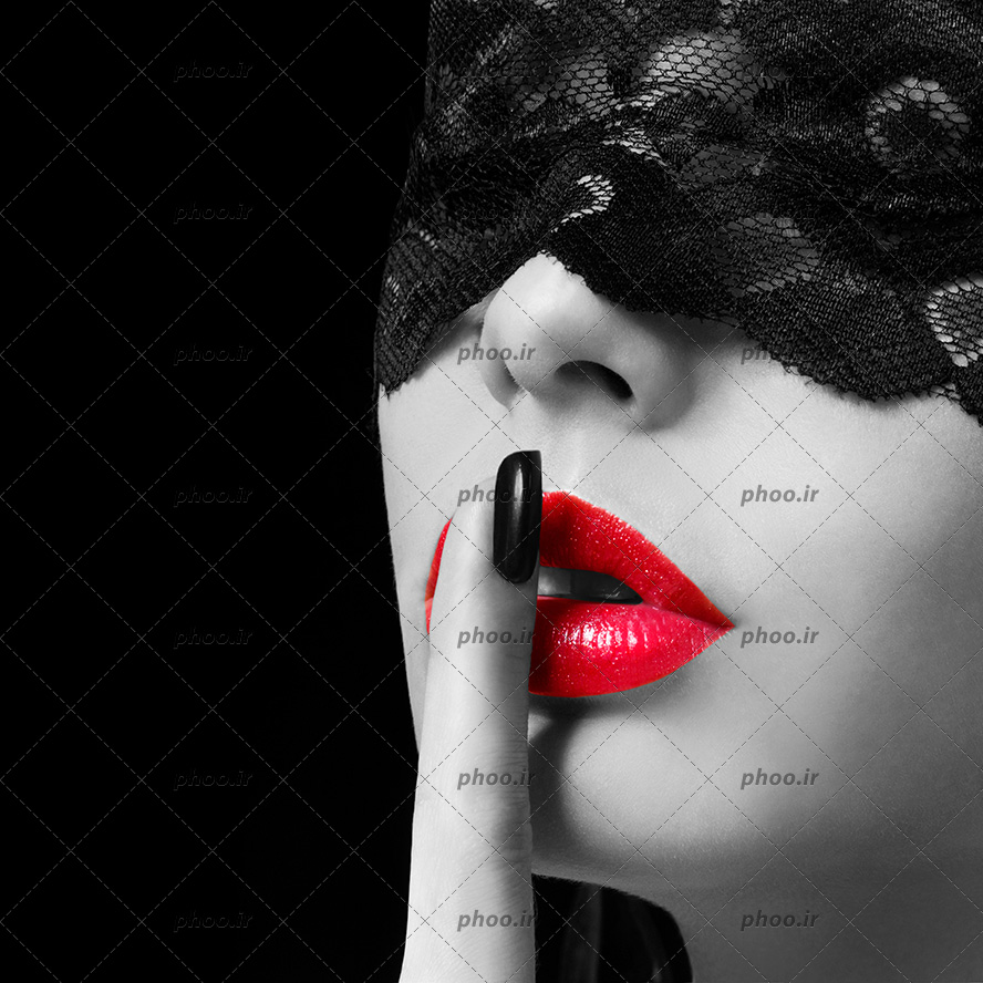 عکس سیاه و سفید زنی با انگشت روی لب های قرمزش و با ماسک توری در پس زمینه سیاه