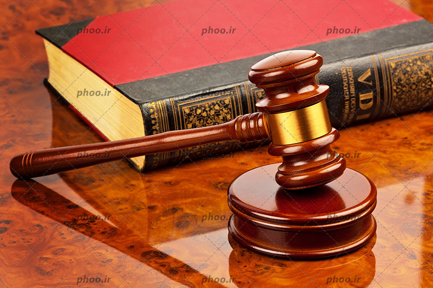 عکس با کیفیت چکش عدالت و کتاب قانون روی میز چوبی