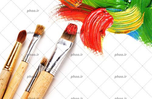 عکس تکه کوچک رنگ های قرمز و زرد و سبز و آبی روی زمینه سفید به همراه قلم مو های رنگی