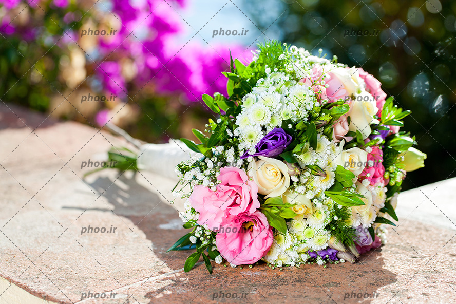 عکس دسته گل عروس رنگارنگ روی سنگ