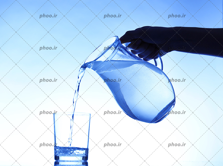 عکس ریختن آب از پارچ در لیوان در پس زمینه آبی