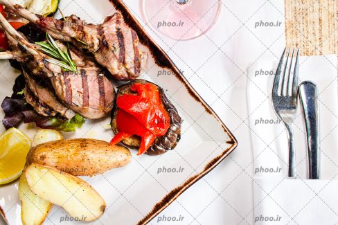 عکس غذا گوشتی داخل ظرف با چنگال و از زاویه بالا