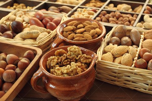 عکس با کیفیت آجیل های مختلف در ظرف های چوبی و سفالی و سبد