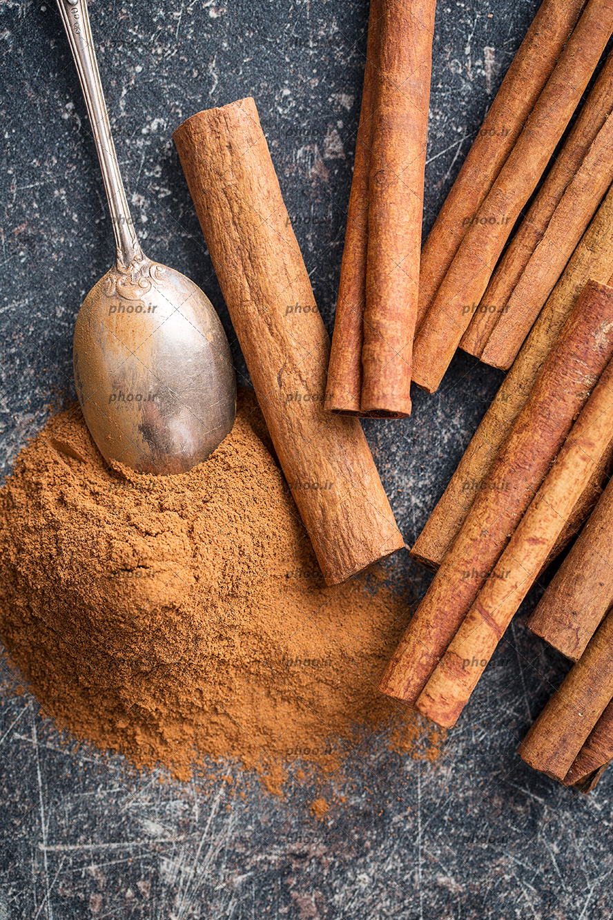 عکس چوب و پودر دارچین در پس زمینه مشکی