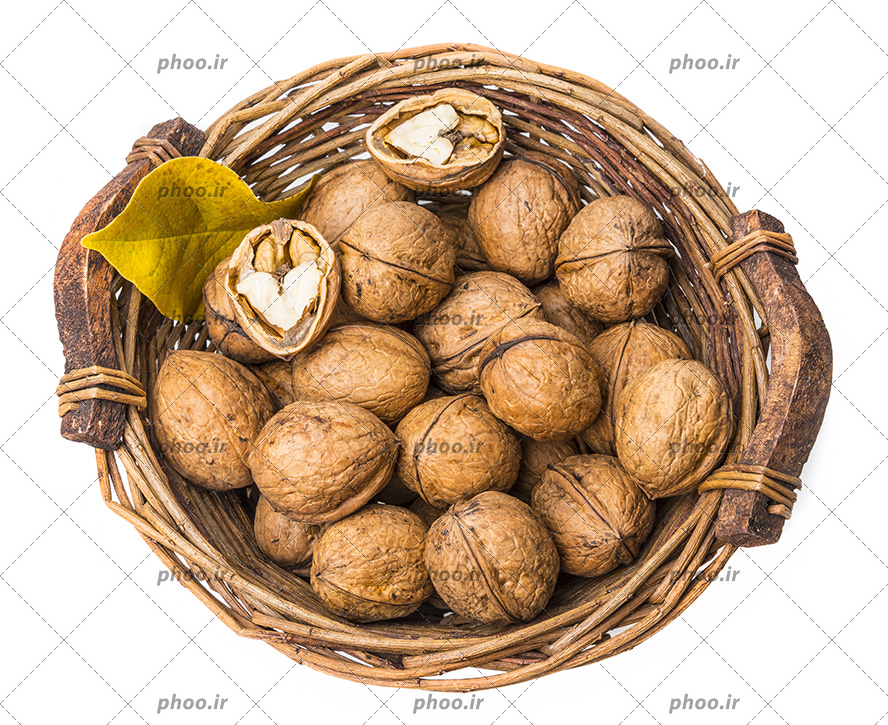 عکس گردو ها در سبد چوبی و یک گردوی شکسته از نمای بالا