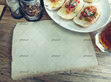 عکس با کیفیت کاغذ قدیمی خالی در کنار لیوان نوشیدنی و ساندویچ در ظرف