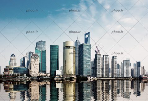 عکس زیبا ساختمان های مدرن و بلند و اسمان ابی در کنار اب