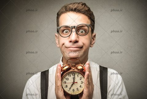 عکس با کیفیت مردی که یک ساعت را در میان دستانش گرفته است