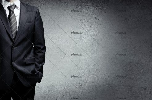 عکس با کیفیت مرد با کت شلوار و کروات در پس زمینه خاکستری