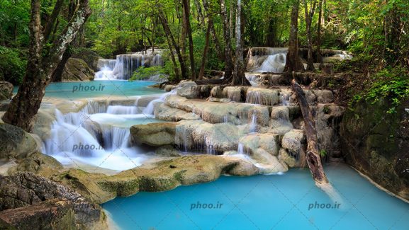 عکس طبیعت زیبا آبشار با صخره سنگ ها و درختان سبز و آب آبی