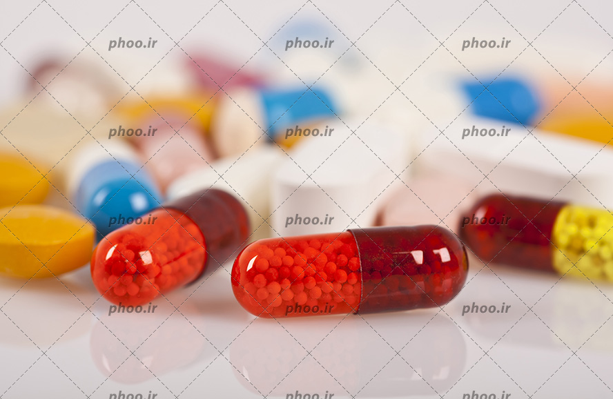 عکس کپسول های رنگارنگ در زمینه سفید