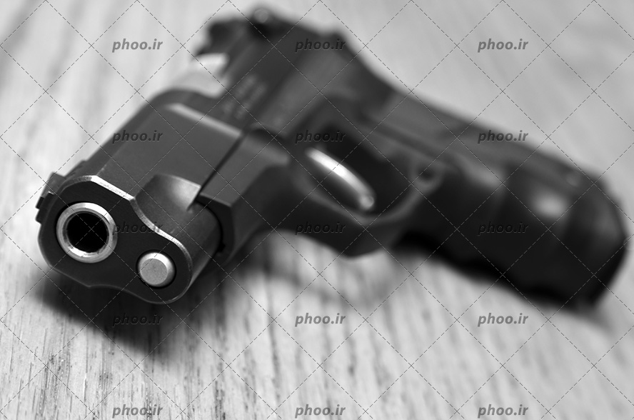 عکس با کیفیت تفنگ مشکی در پس زمینه چوبی