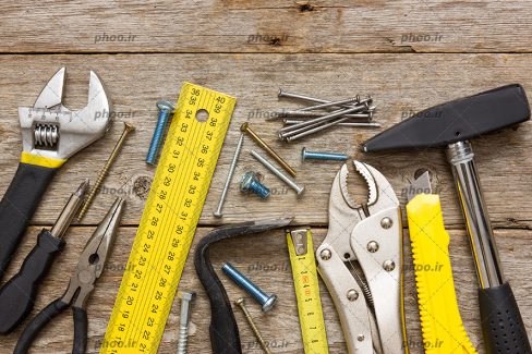 عکس ابزار های متفاوت روی یک میز چوبی