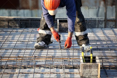 عکس کارگر ساختمانی در حال کار با ابزار