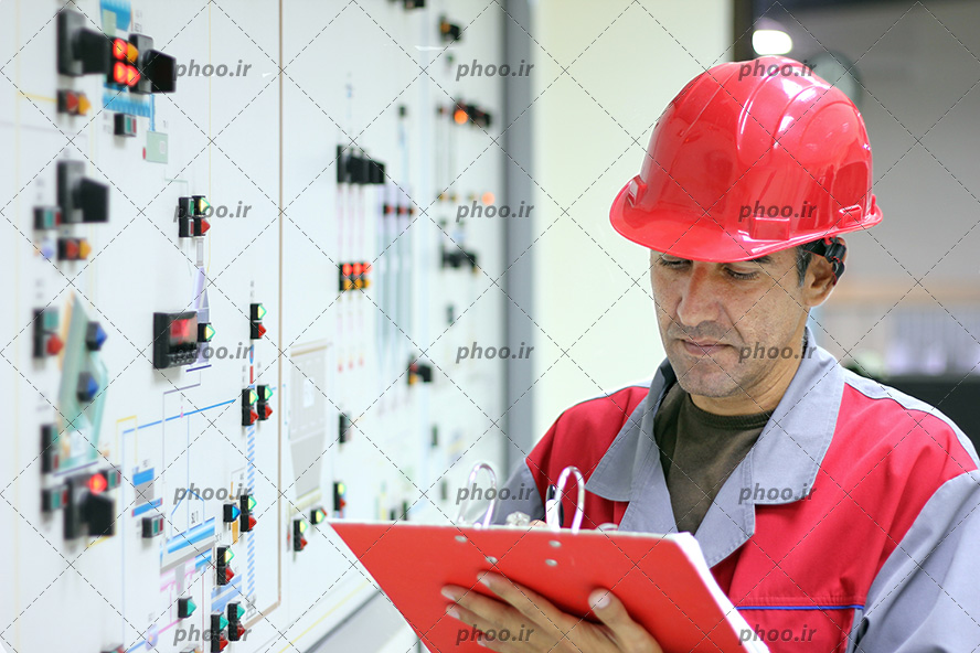 عکس مهندس ایستاده در مقابل کنترل پنل در اتاق کنترل و نتایج حاصل از اندازه گیری می نویسد