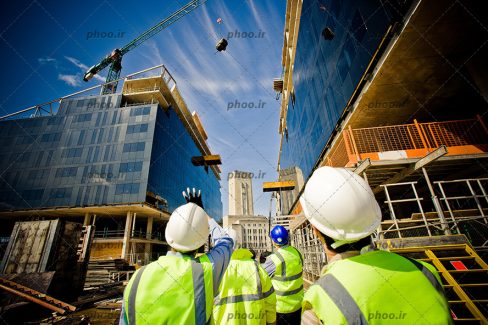 عکس مهندسین ناظر در حال نظارت و کنترل بر کار کارگران ساختمان