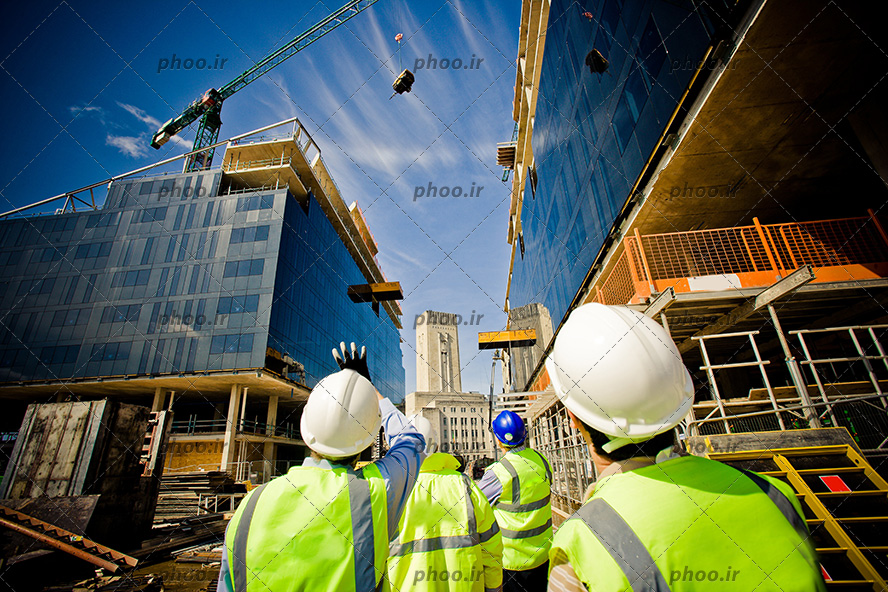 عکس مهندسین ناظر در حال نظارت و کنترل بر کار کارگران ساختمان