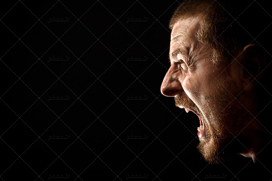عکس یک مرد عصبانی در حال فریاد زدن در پس زمینه مشکی