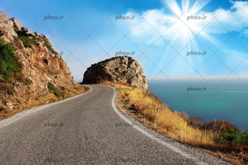 عکس با کیفیت جاده ساحلی که از کنار دریا و کوه می گذرد