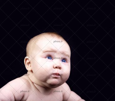 عکس با کیفیت کودک تپل مپل زیبا با چشم های آبی در پس زمینه مشکی